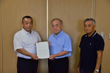 中村会長（中央）と中田副会長（右）から、富田教育長へ答申書を提出
